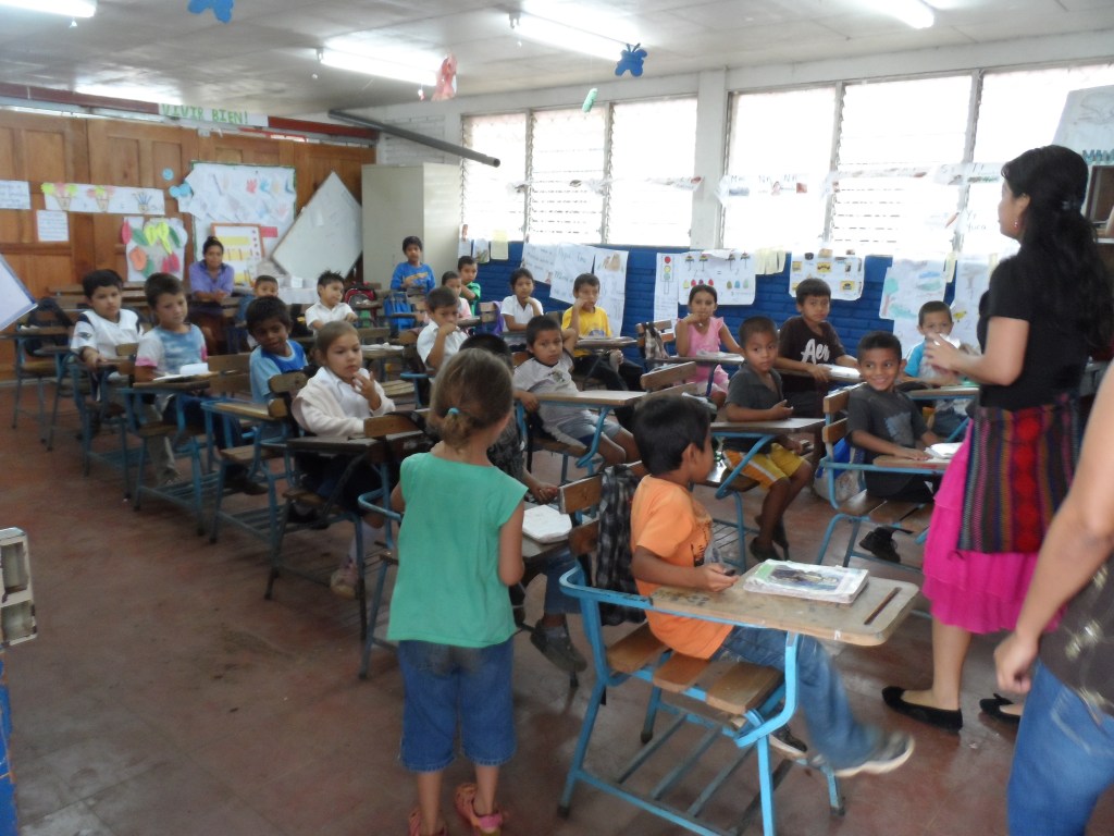 Emma handing out pens in a class.