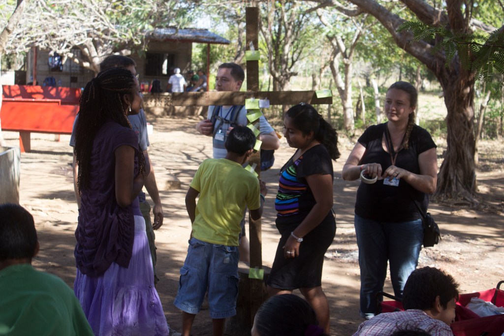 Kids hanging their sins on the cross in the childrens' discipleship program. 